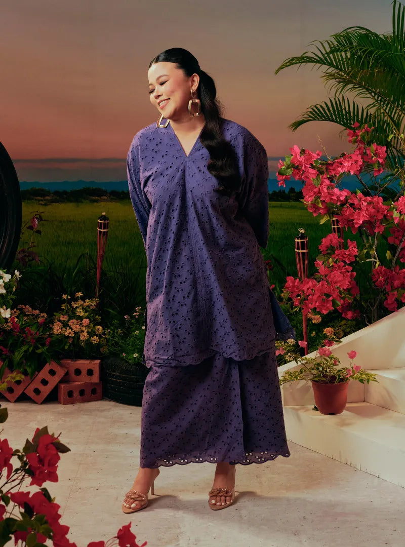 A woman dressed in Dusty Purple Tun Yasmin Embroidered Eyelet Oversized Kurung