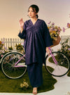 A woman dressed in Dusty Purple Tun Yasmin Embroidered Eyelet Oversized Kurung