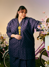 A woman dressed in Dusty Purple Tun Yasmin Embroidered Eyelet Oversized Kurung