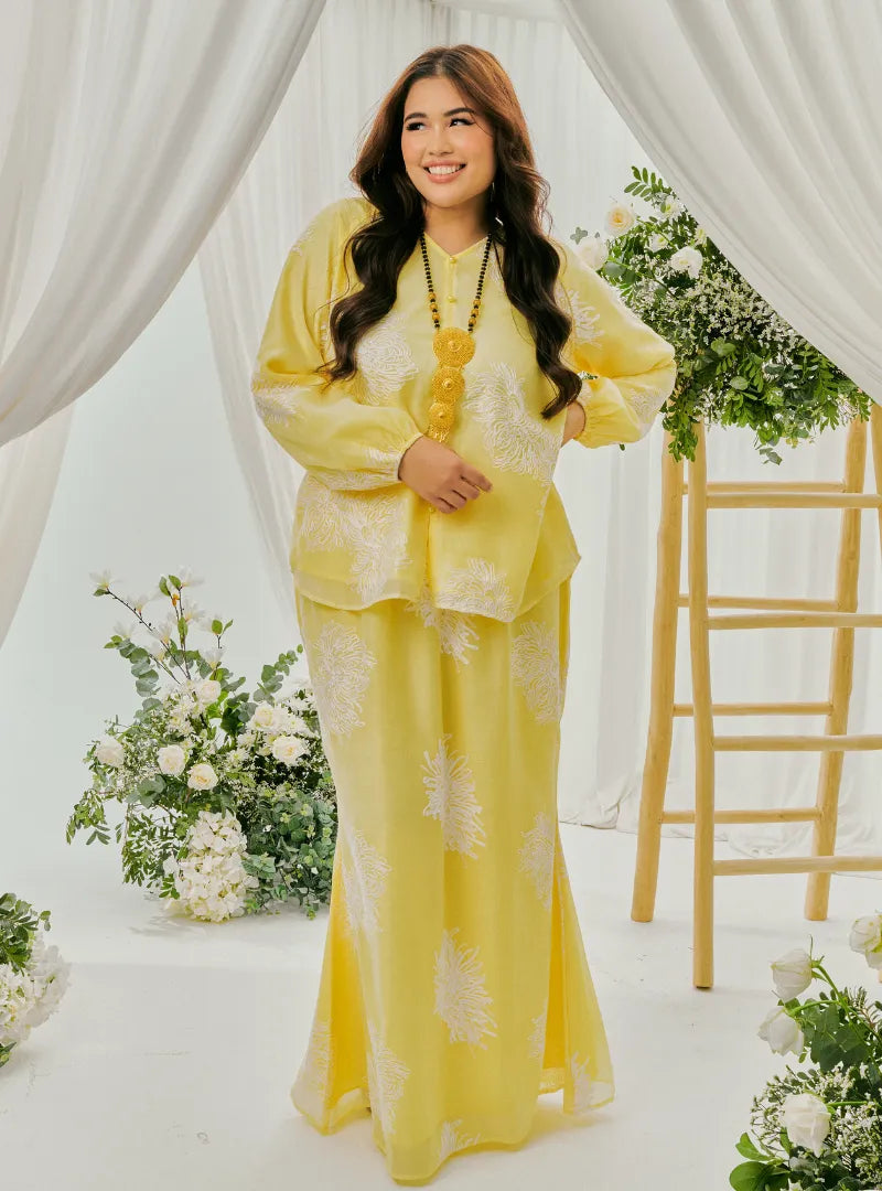 A woman dressed in Egg Nog Tun Iman Mandarin Kurung