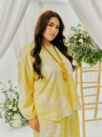 A woman dressed in Egg Nog Tun Iman Mandarin Kurung