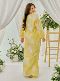 A woman dressed in Egg Nog Tun Iman Mandarin Kurung