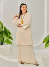 A woman dressed in Egg White Tun Bibah Textured Kurung