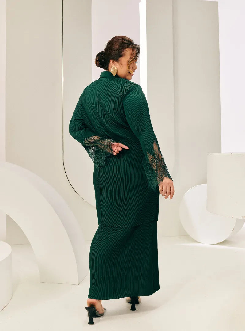 A woman dressed in Emerald Green Tun Jamilah Pleated Kurung