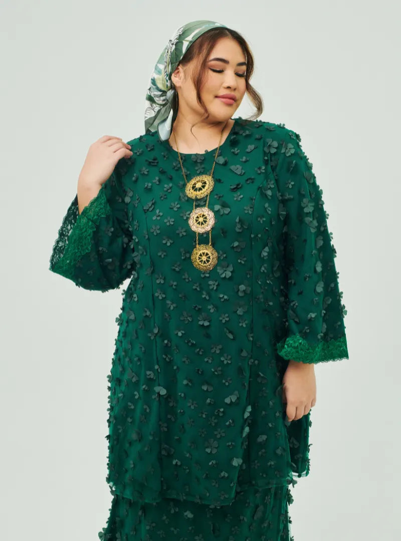 A woman dressed in Emerald Green Tun Sharifah Lace Kurung