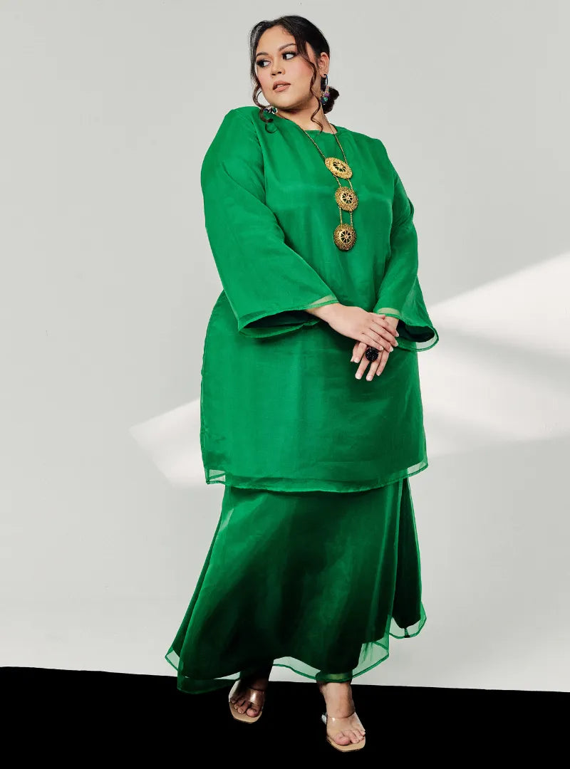 A woman dressed in Emerald Green Tun Sharimah Organza Kurung