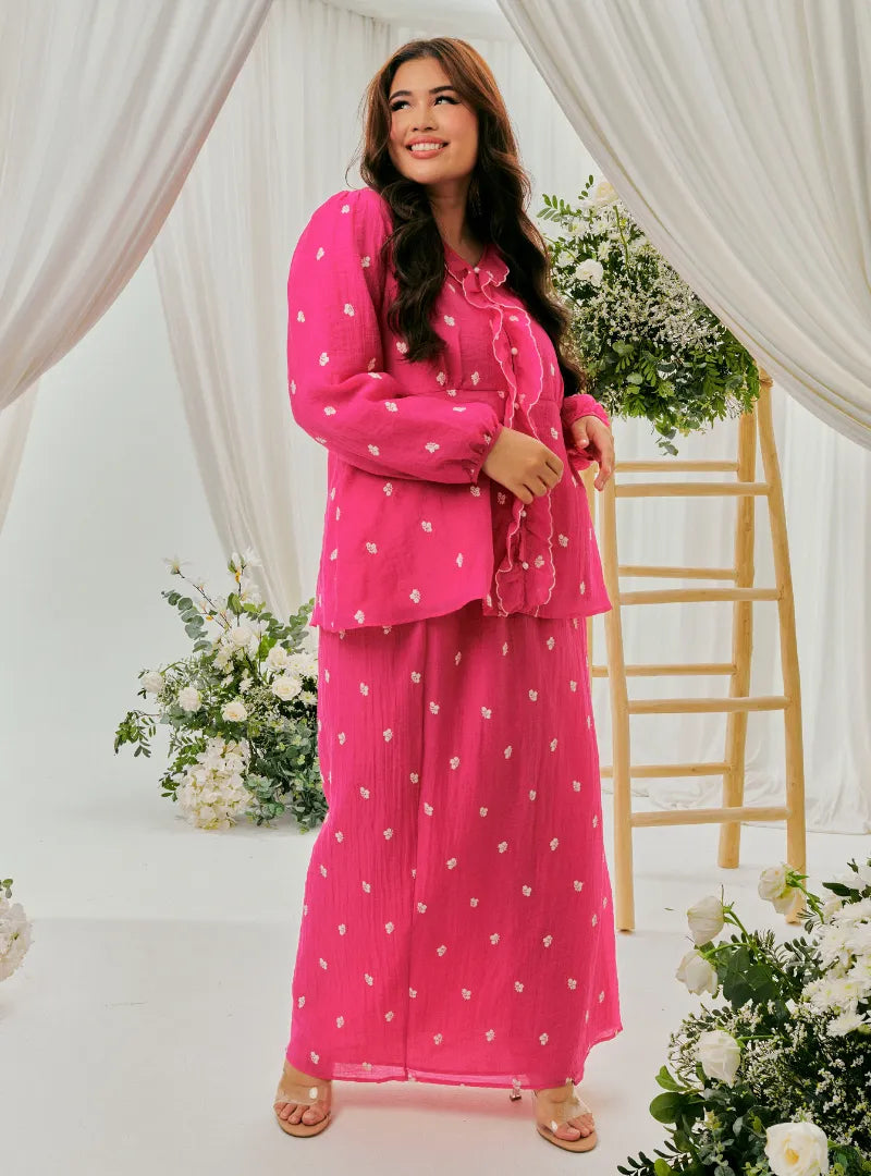  A woman dressed in Fuschia Tun Anisah Kebaya Kurung