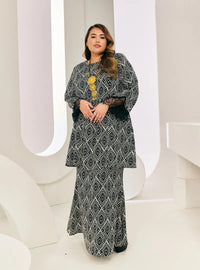 A woman dressed in Geometric Black Tun Rokiah Printed Kurung Pahang