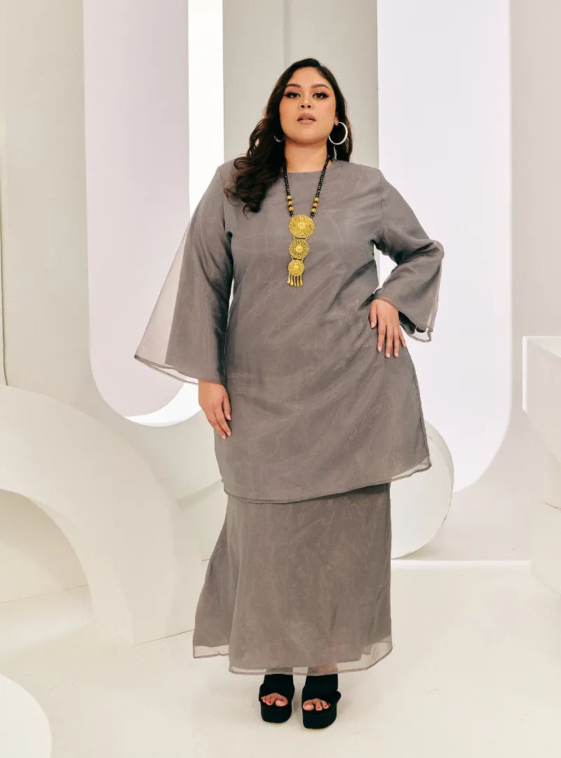 A woman dressed in Grey Tun Sharimah Organza Kurung