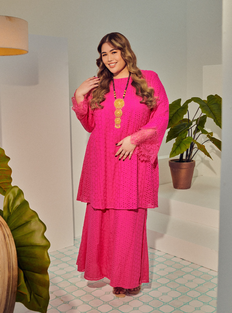 A woman dressed in Hot Pink Tun Rosmiza Eyelet Embroidered Patchwork Kurung