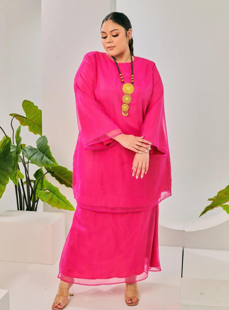 A woman dressed in Hot Pink Tun Sharimah Organza Kurung