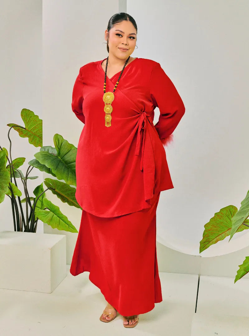 A woman dressed in Hot Red Tun Malika Feather Wrap Kurung