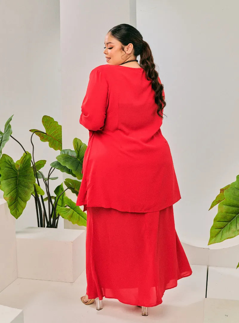 A woman dressed in Hot Red Tun Malika Feather Wrap Kurung