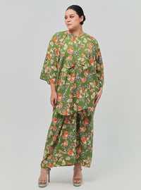 A woman dressed in Jowo Green The Vintage Opah Kurung