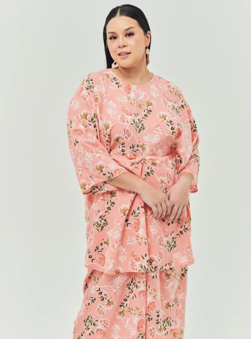 A woman dressed in Jowo Peach The Vintage Opah Kurung