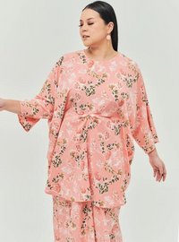 A woman dressed in Jowo Peach The Vintage Opah Kurung