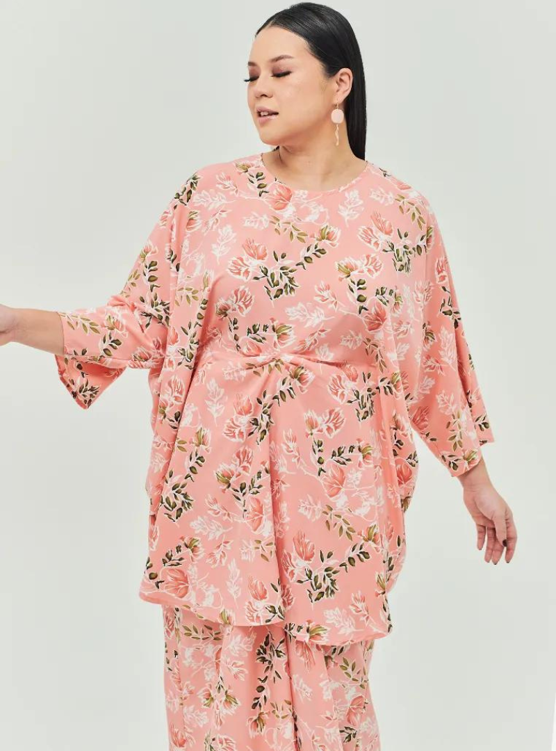 A woman dressed in Jowo Peach The Vintage Opah Kurung