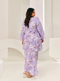 A woman dressed in Lilac Flower Tun Rokiah Printed Kurung Pahang