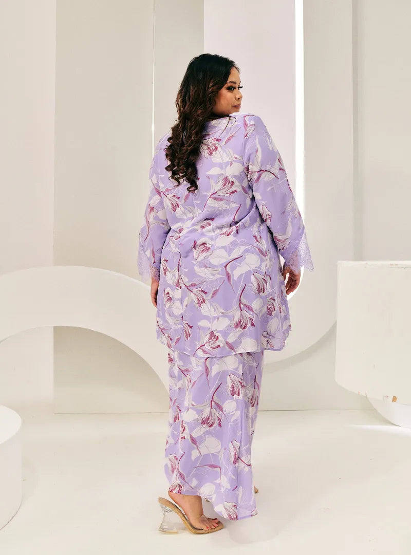 A woman dressed in Lilac Flower Tun Rokiah Printed Kurung Pahang