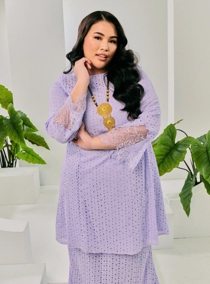 A woman dressed in Lilac Tun Inna Kurung