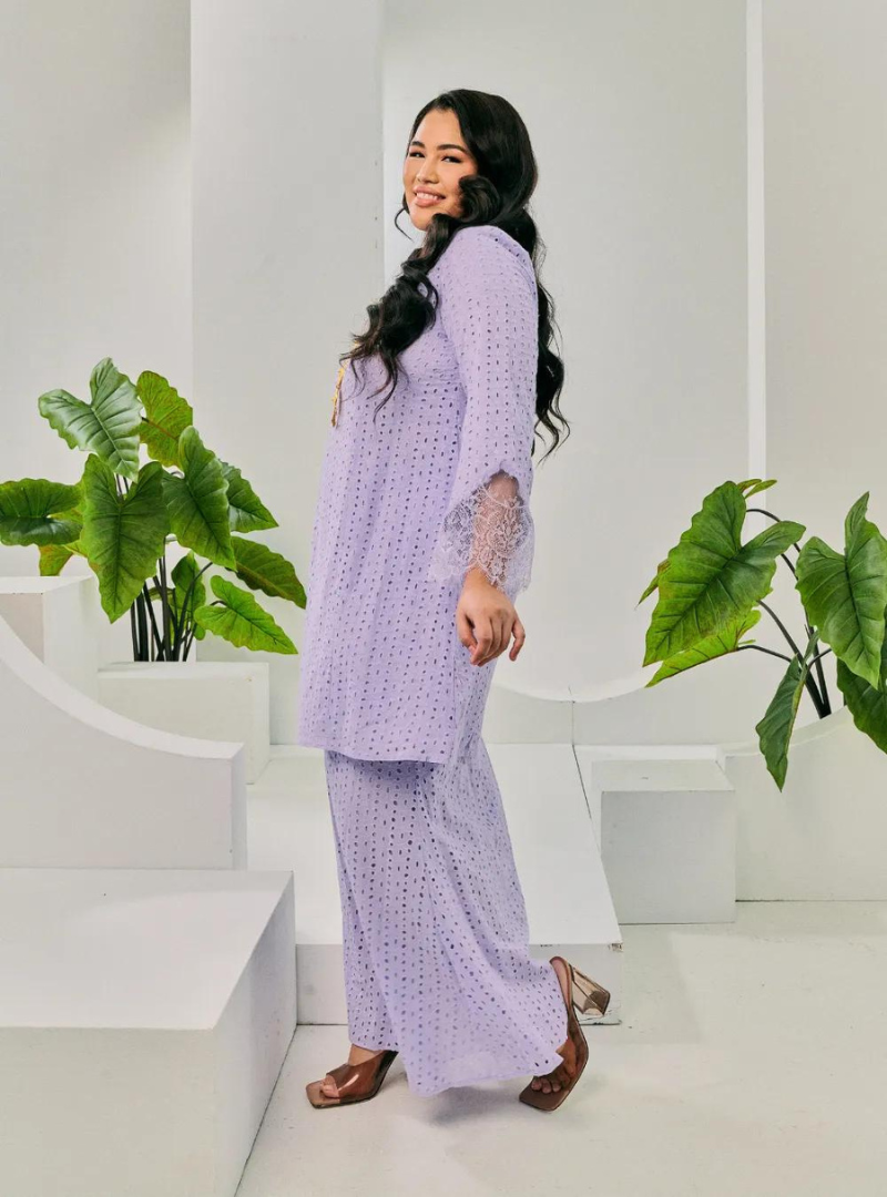 A woman dressed in Lilac Tun Inna Kurung