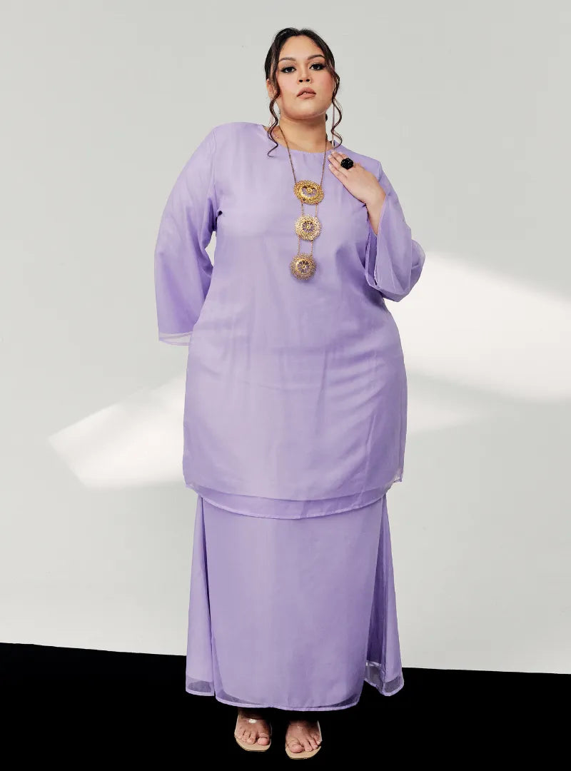 A woman dressed in Lilac Tun Sharimah Organza Kurung