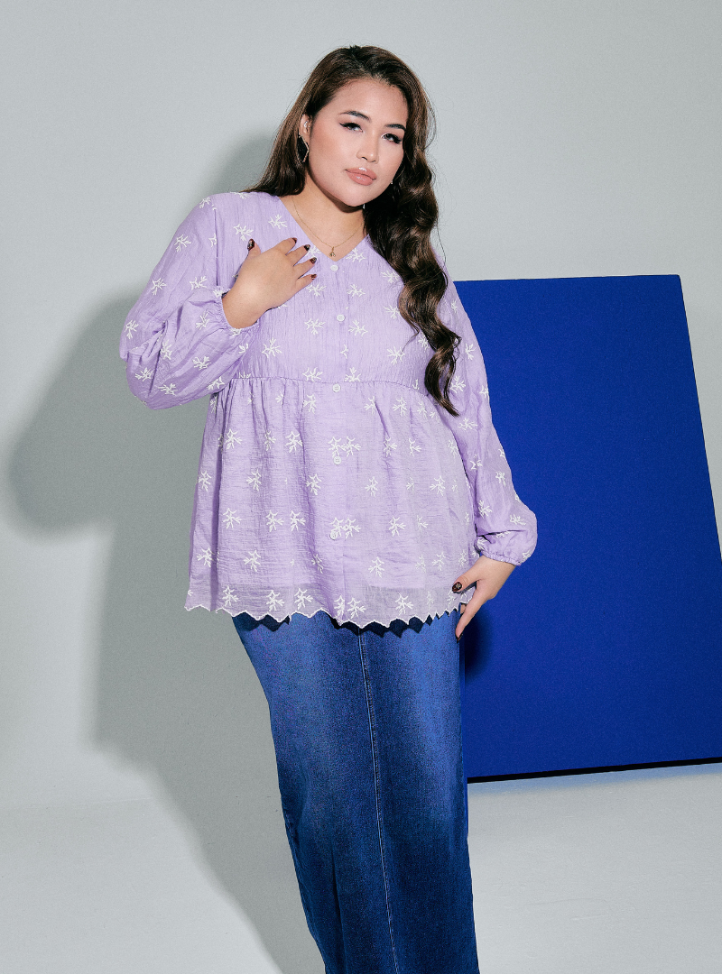 A woman dressed in Lilac Tun Ava Peplum Embroidered Top