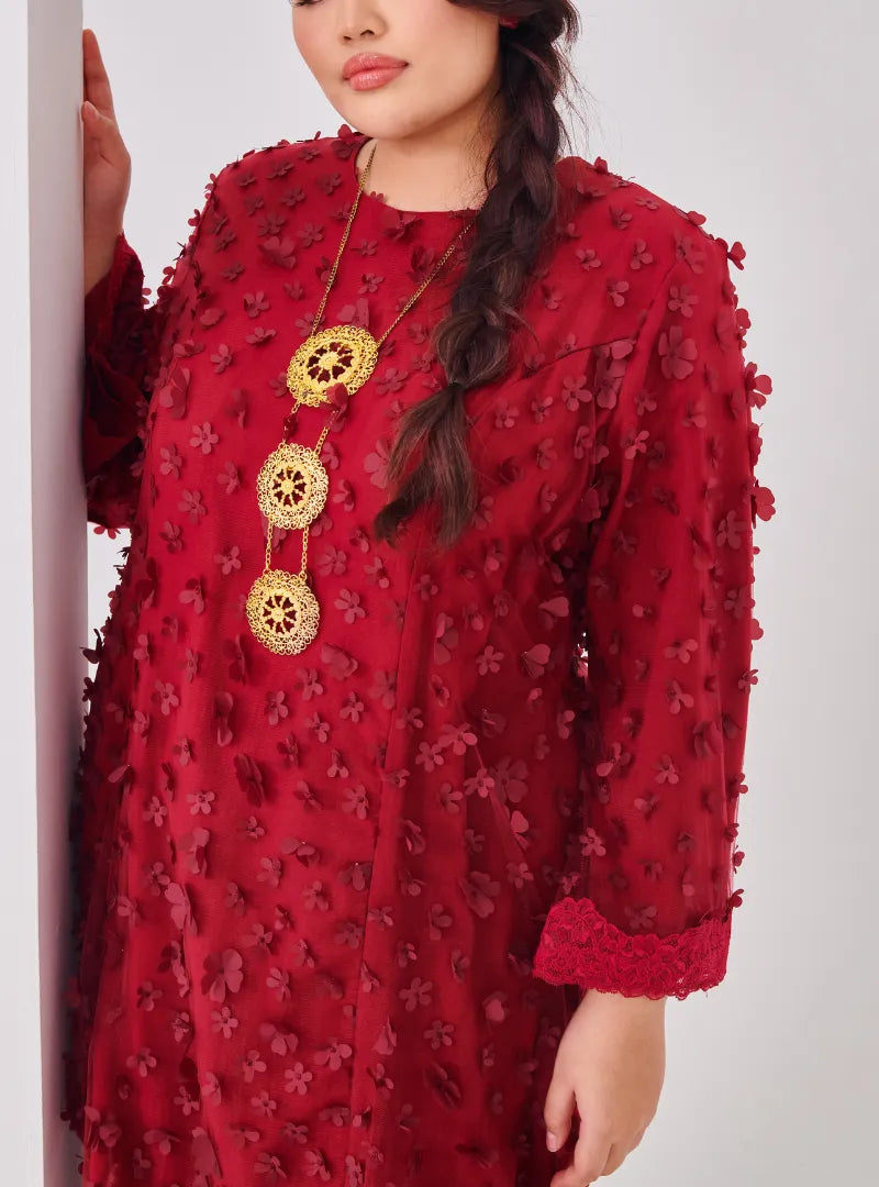 A woman dressed in Maroon Tun Sharifah Lace Kurung