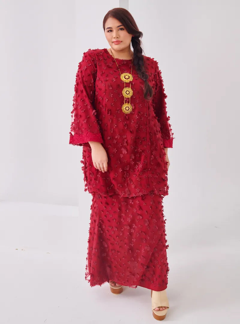 A woman dressed in Maroon Tun Sharifah Lace Kurung