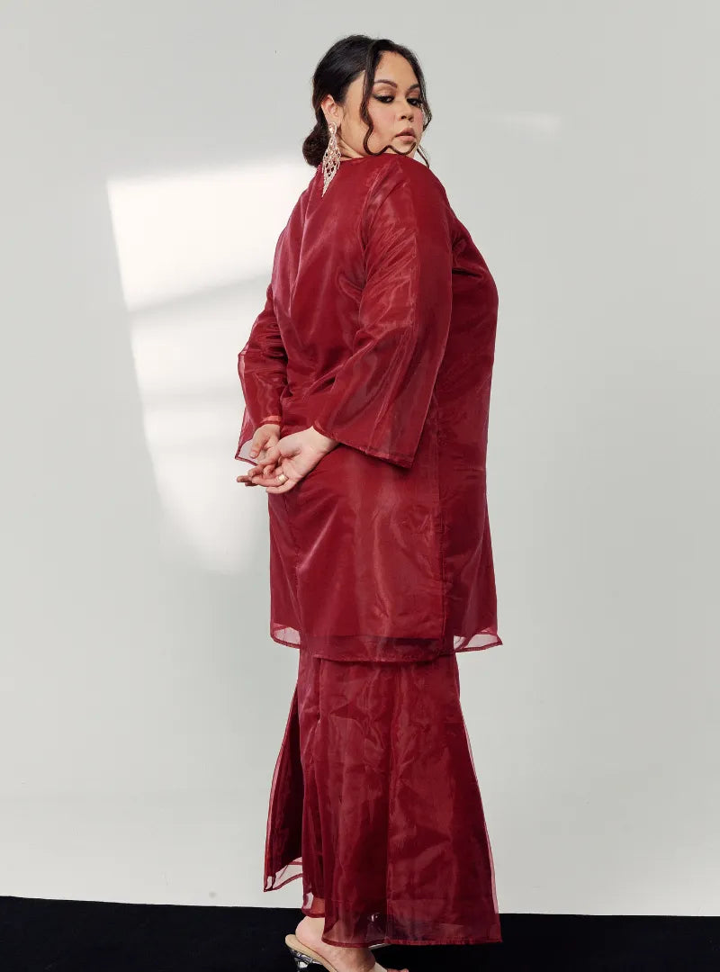 A woman dressed in Maroon Tun Sharimah Organza Kurung