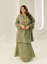 A woman dressed in Mint Green Tun Maryam Eyelet Kurung