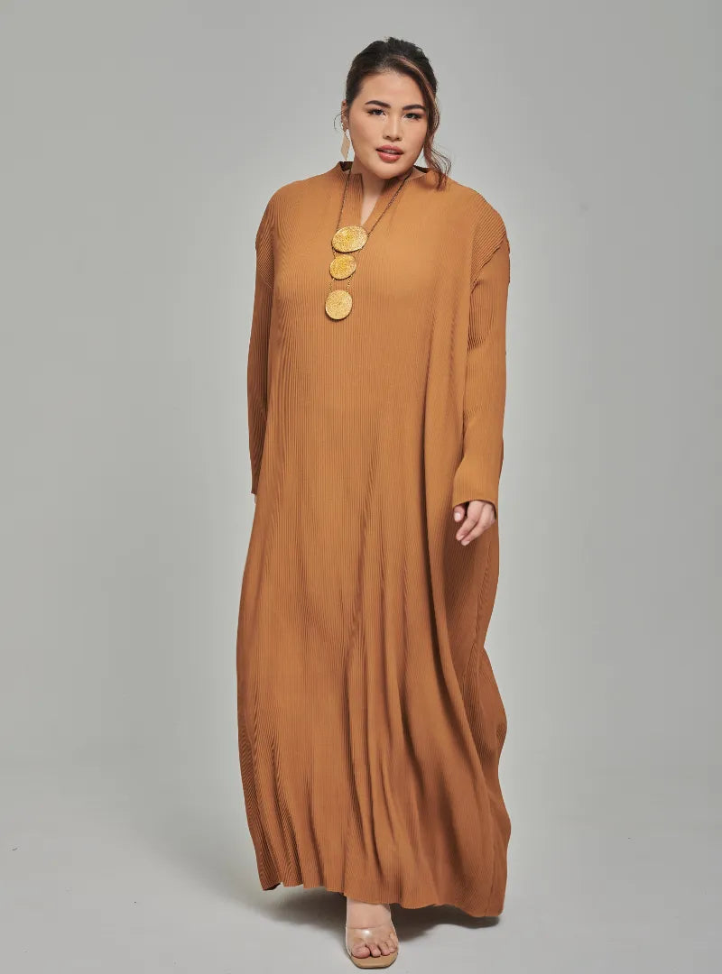 A woman dressed in Mocha Tun Aimellia Pleated Maxi Dress