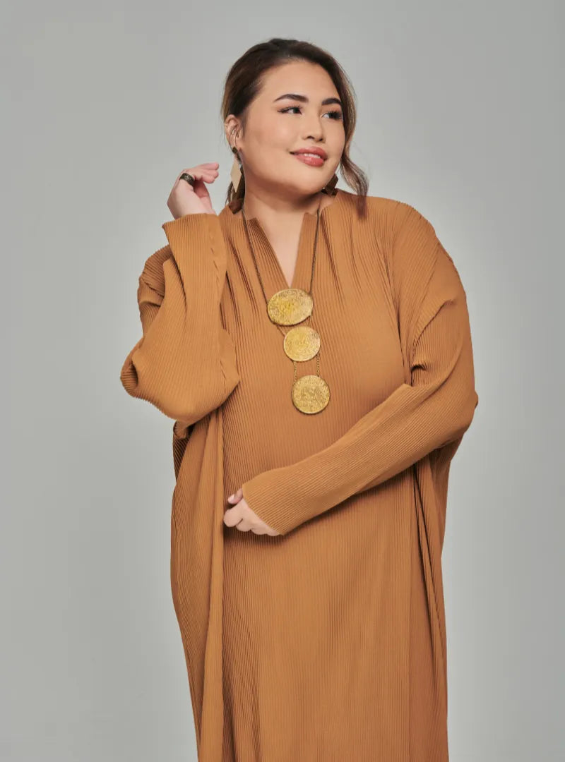 A woman dressed in Mocha Tun Aimellia Pleated Maxi Dress