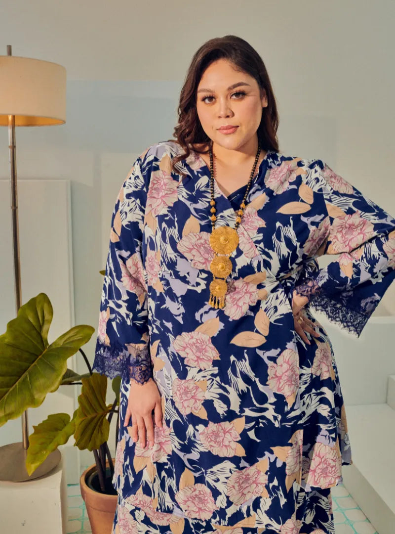 A woman dressed in Navy Tun Anum Printed Wrap Kurung