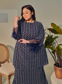 A woman dressed in Navy Tun Maryam Eyelet Kurung