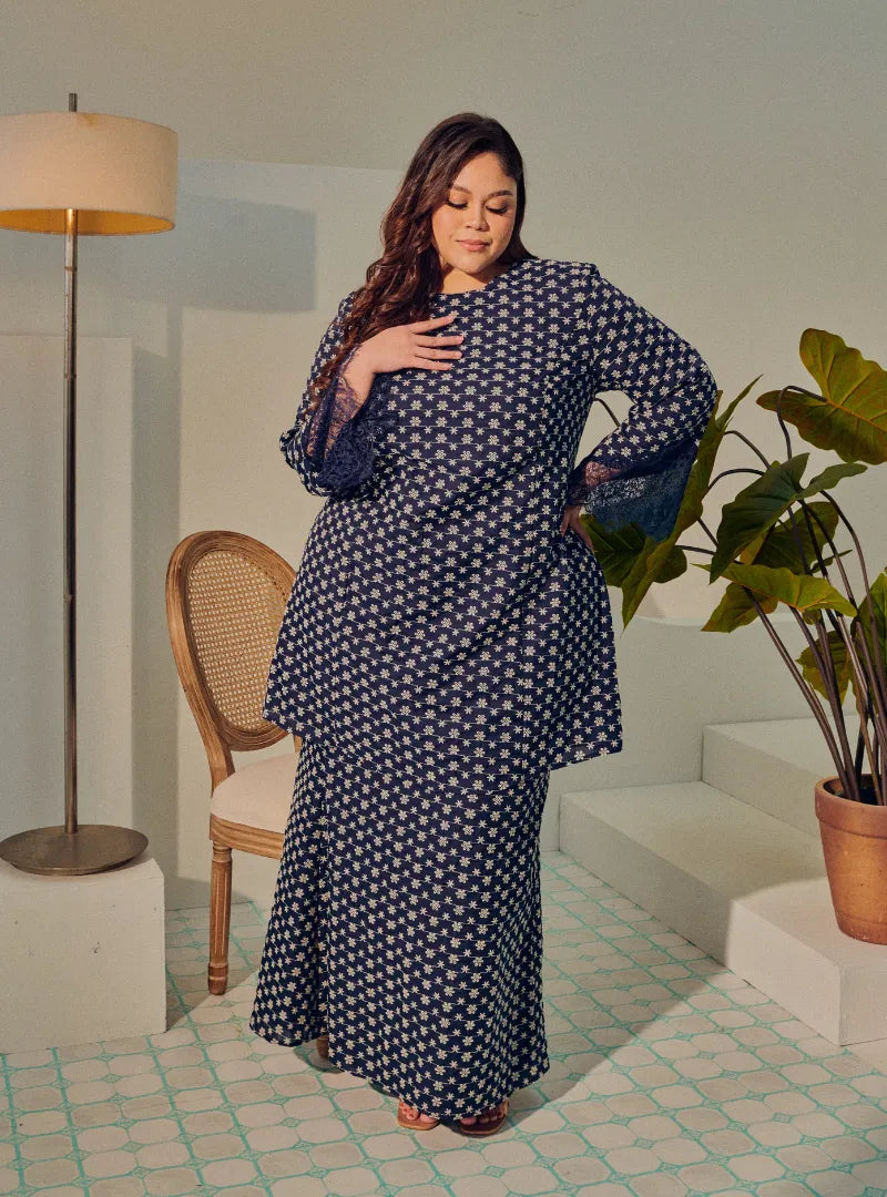 A woman dressed in Navy Tun Maryam Eyelet Kurung