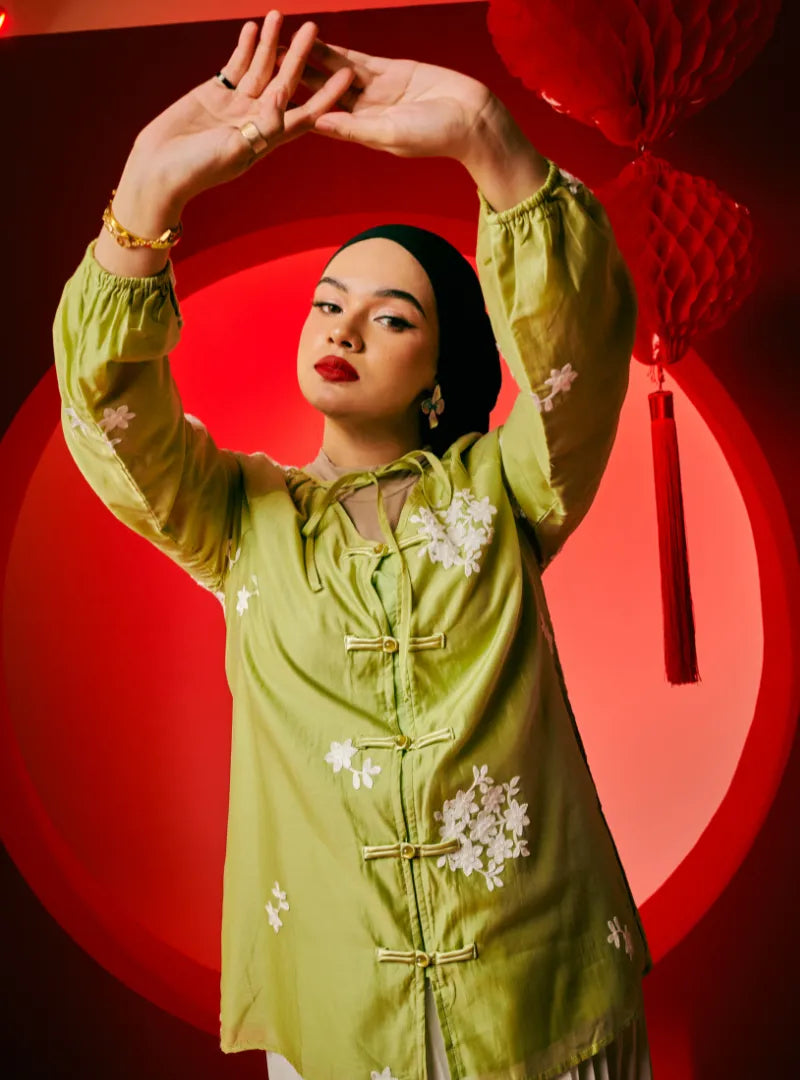 A woman dressed in Olive Tea Wong Gu Embroidered Cheongsam Top