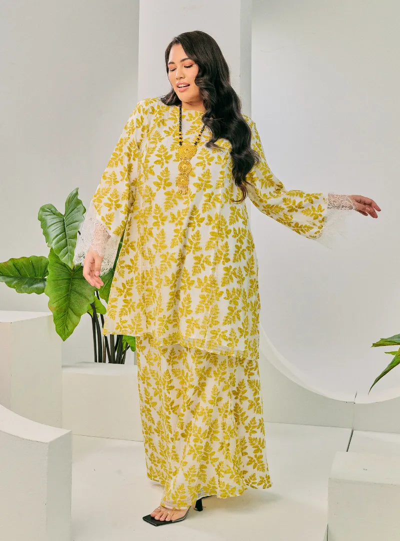 A woman dressed in Olive Tun Kuntom Cotton Lace Kurung