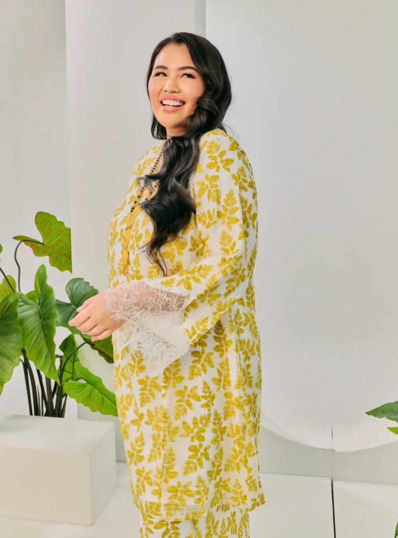 A woman dressed in Olive Tun Kuntom Cotton Lace Kurung