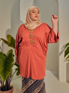 A woman dressed in Orange Tun Bedah Top