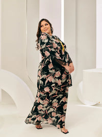 A woman dressed in Pink Flower Tun Rokiah Printed Kurung Pahang