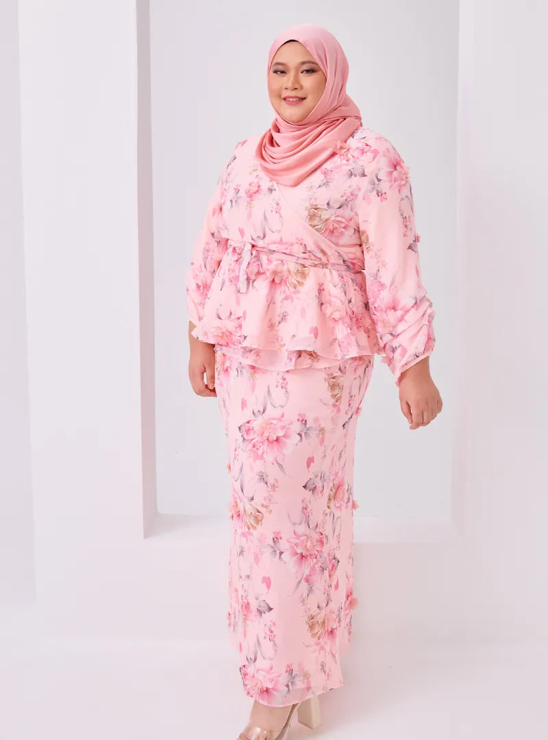 A woman dressed in Pink Tun Hamidah Chiffon Wrap Kurung