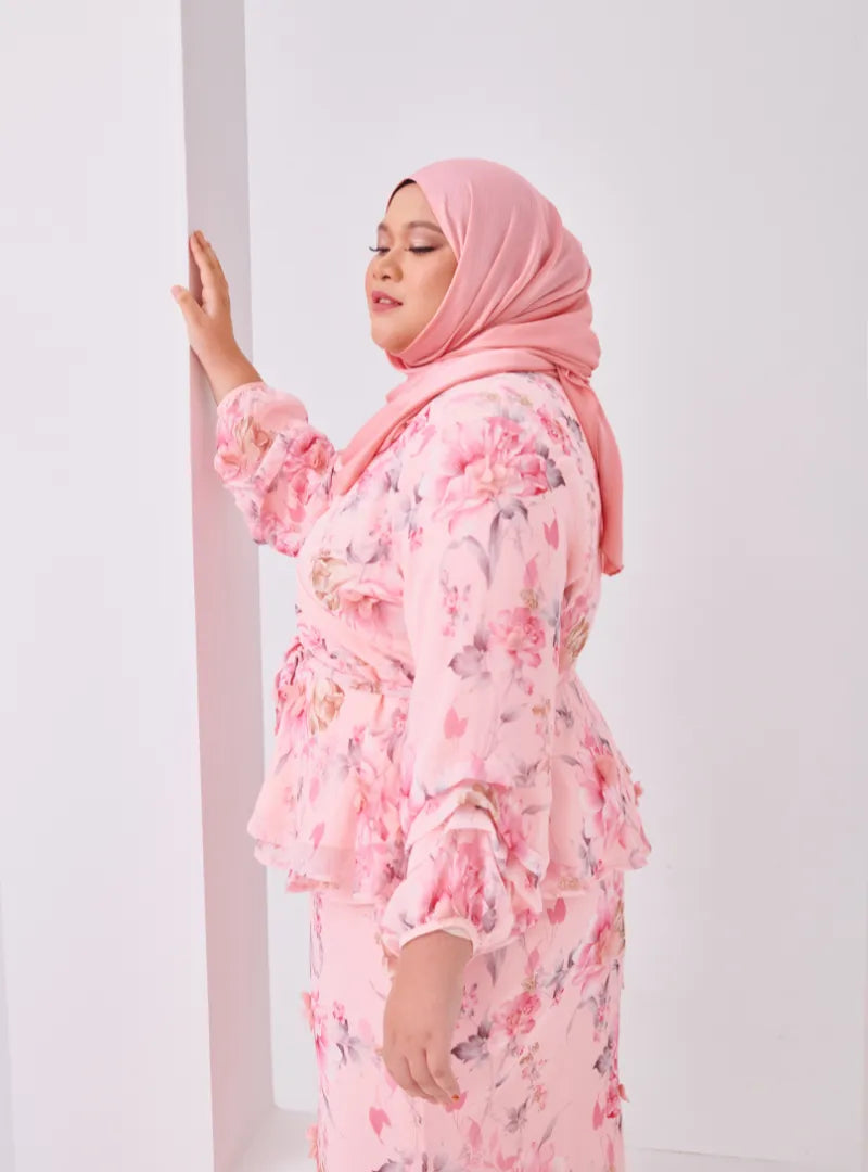 A woman dressed in Pink Tun Hamidah Chiffon Wrap Kurung