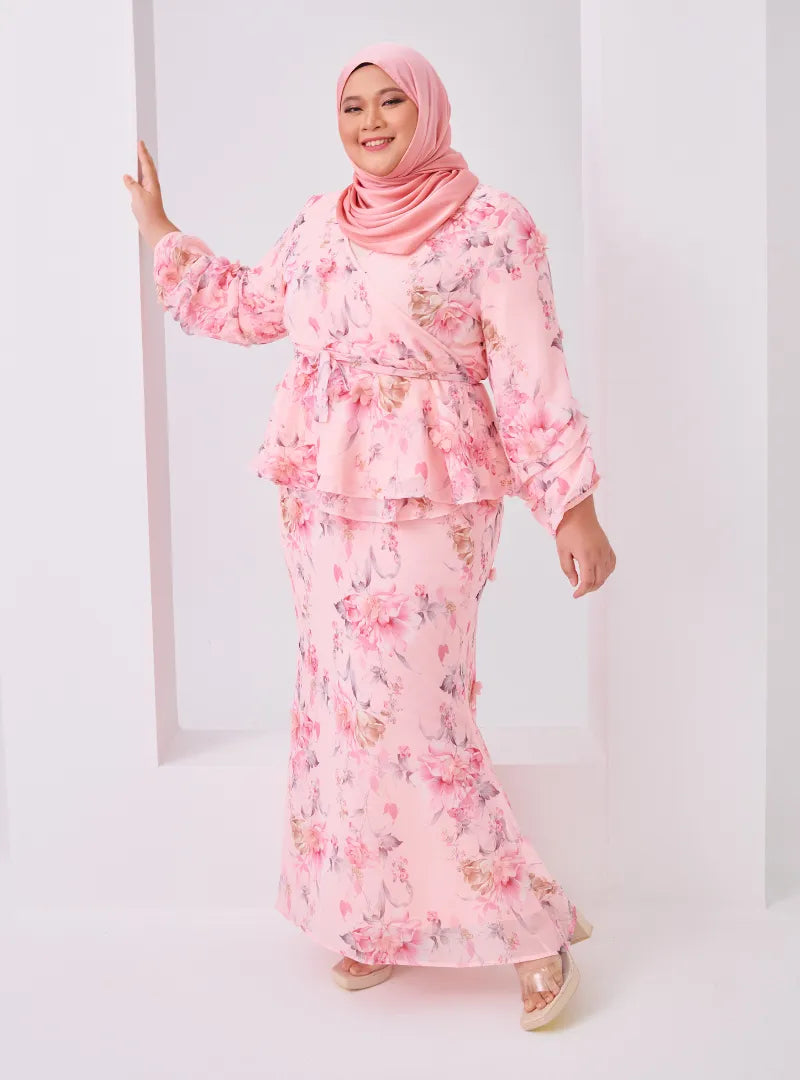 A woman dressed in Pink Tun Hamidah Chiffon Wrap Kurung