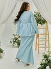 A woman dressed in Powder Blue Tun Zera Eyelet Kurung