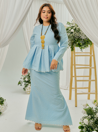 A woman dressed in Powder Blue Tun Zera Eyelet Kurung