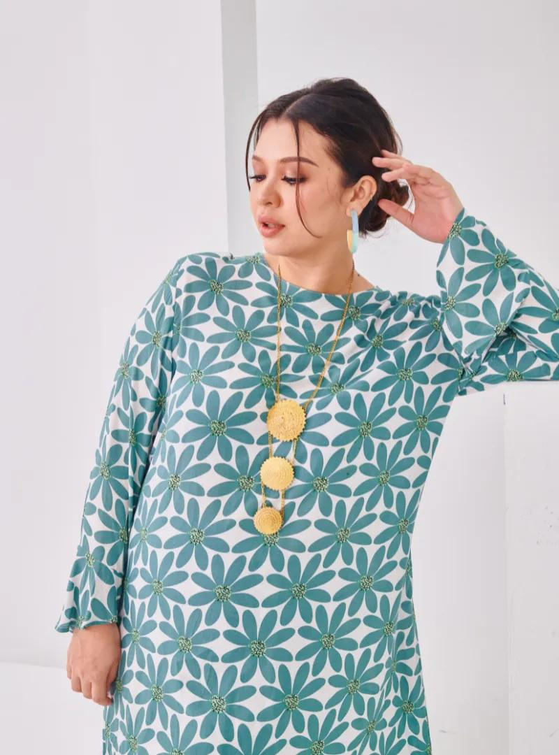 A woman dressed in Mint Daisy Premium Cotton Kurung