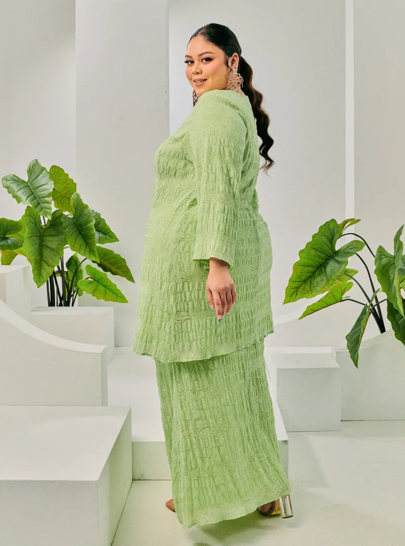 A woman dressed in Pucuk Pisang Tun Bibah Textured Kurung