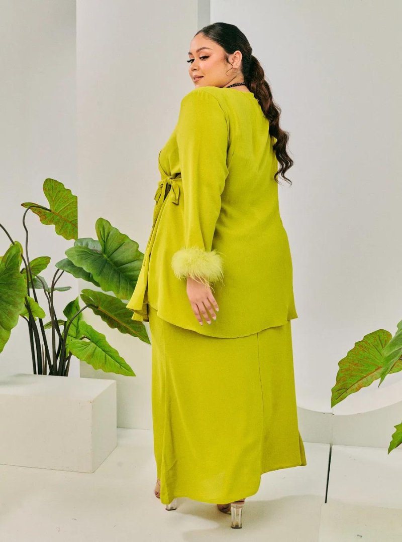 A woman dressed in Pucuk Pisang Tun Malika Feather Wrap Kurung