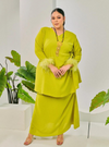 A woman dressed in Pucuk Pisang Tun Malika Feather Wrap Kurung